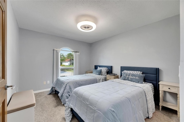 bedroom featuring a textured ceiling and light carpet