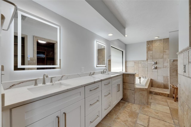 bathroom featuring vanity and tiled tub