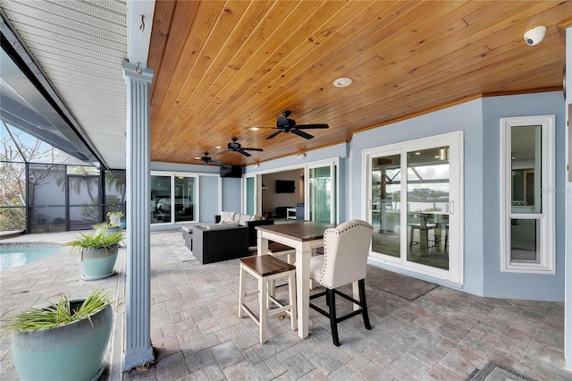 view of patio featuring outdoor lounge area, glass enclosure, and ceiling fan