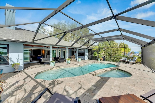 view of pool with glass enclosure, ceiling fan, a patio, and an in ground hot tub