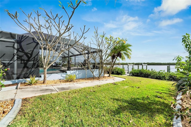 view of yard with a lanai and a water view