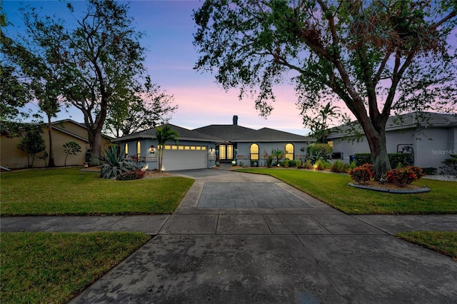 single story home with a yard and a garage