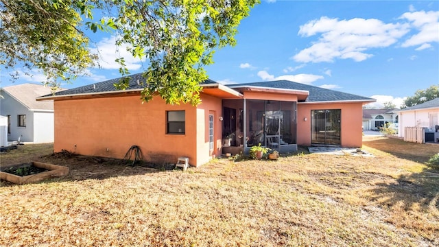 rear view of house featuring a sunroom