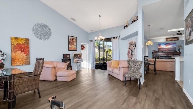 living room with hardwood / wood-style floors, high vaulted ceiling, and ceiling fan with notable chandelier