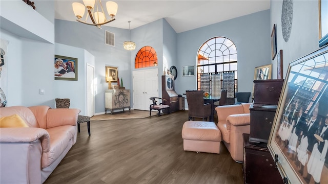 living room featuring a notable chandelier, dark hardwood / wood-style floors, and a towering ceiling