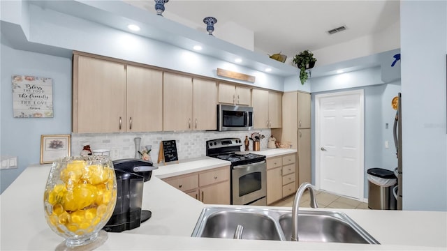 kitchen with backsplash, sink, light brown cabinets, and appliances with stainless steel finishes