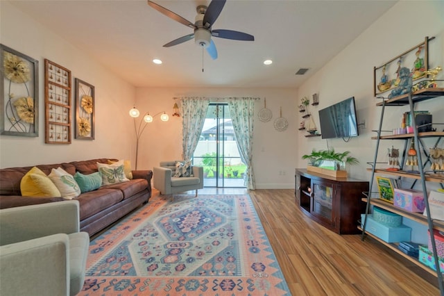 living room with ceiling fan and light hardwood / wood-style flooring