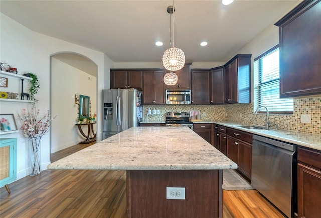 kitchen featuring pendant lighting, sink, a kitchen island, and stainless steel appliances