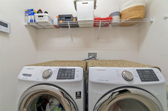 clothes washing area with washing machine and dryer