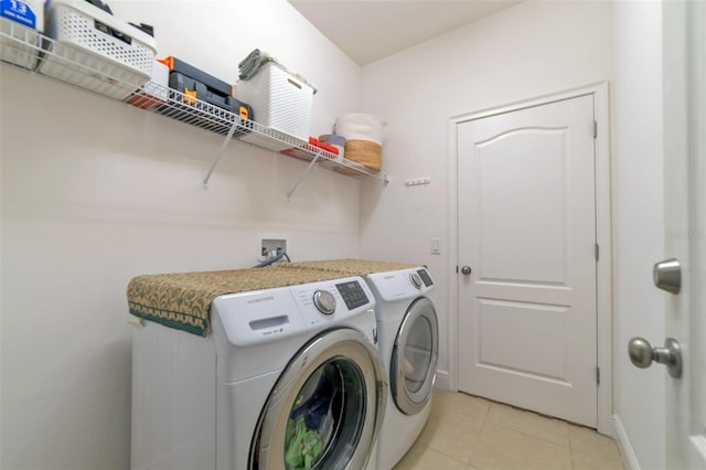 laundry room with washer and clothes dryer and light tile patterned floors