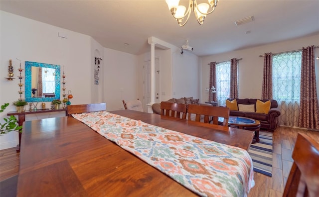 dining space with light hardwood / wood-style floors and an inviting chandelier