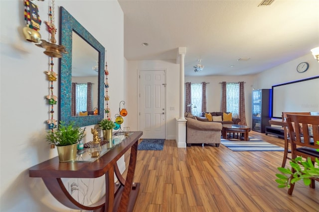 interior space featuring wood-type flooring and decorative columns