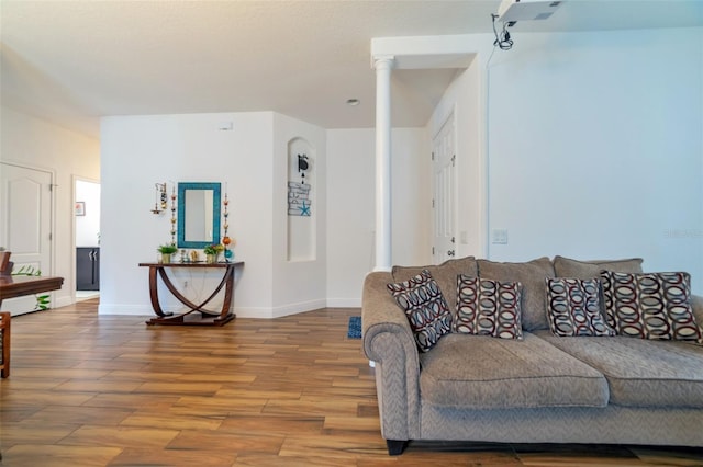 living room with decorative columns and hardwood / wood-style floors