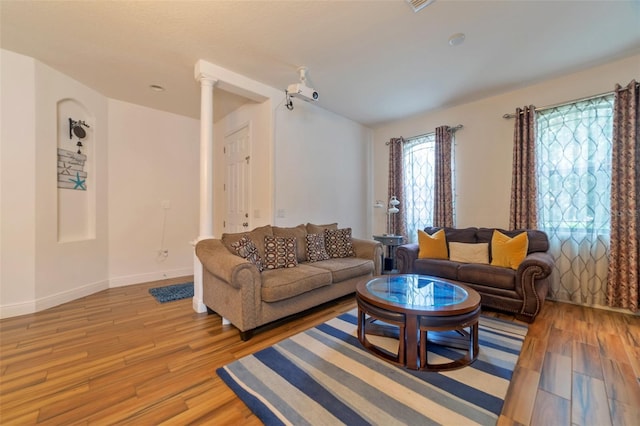 living room featuring light hardwood / wood-style floors and decorative columns