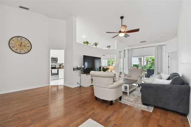 living room with baseboards, a high ceiling, visible vents, and dark wood finished floors