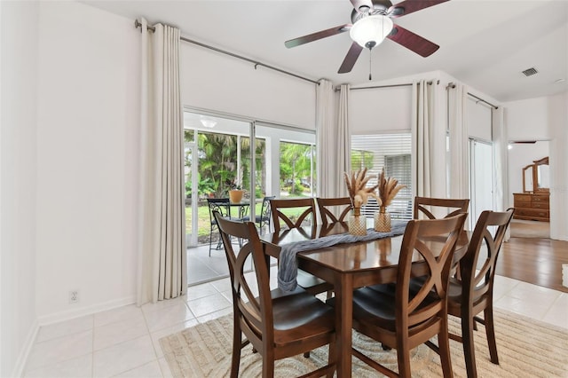 dining space with a ceiling fan, visible vents, baseboards, and light tile patterned flooring