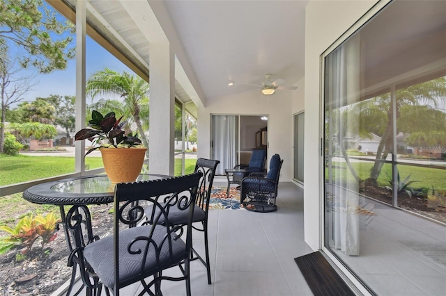 sunroom / solarium with lofted ceiling and a ceiling fan