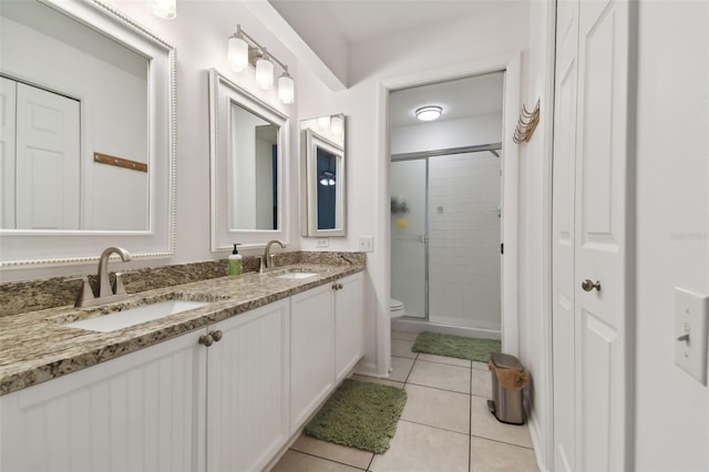 bathroom featuring tile patterned flooring, a closet, a sink, and toilet