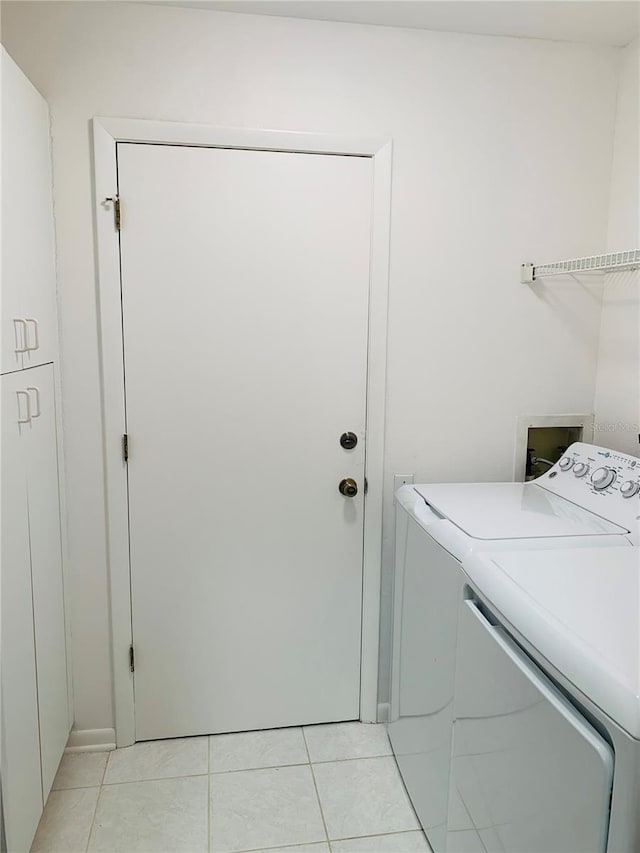 clothes washing area with laundry area, light tile patterned floors, and separate washer and dryer