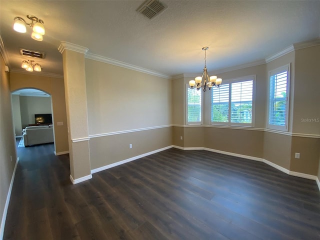 spare room featuring a notable chandelier, dark hardwood / wood-style flooring, and crown molding