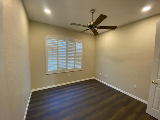 empty room with ceiling fan and dark hardwood / wood-style flooring