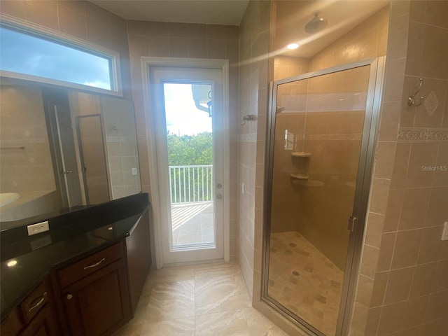 bathroom featuring vanity, a wealth of natural light, and a shower with shower door