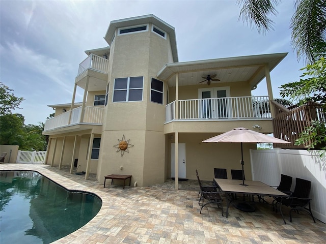 back of house featuring a balcony, a patio area, ceiling fan, and a fenced in pool