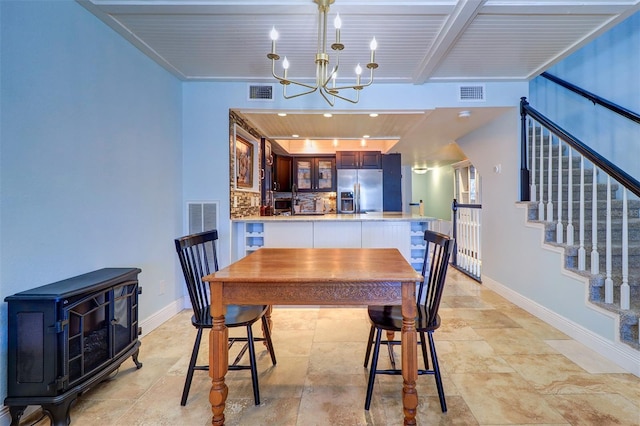 dining space featuring beam ceiling, an inviting chandelier, a wood stove, and wood ceiling