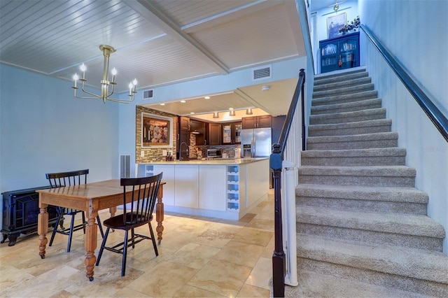 dining room with rail lighting, wood ceiling, a notable chandelier, and sink