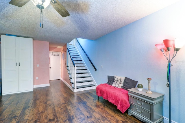 sitting room featuring a textured ceiling, ceiling fan, and dark wood-type flooring