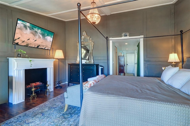 bedroom with dark hardwood / wood-style floors and an inviting chandelier