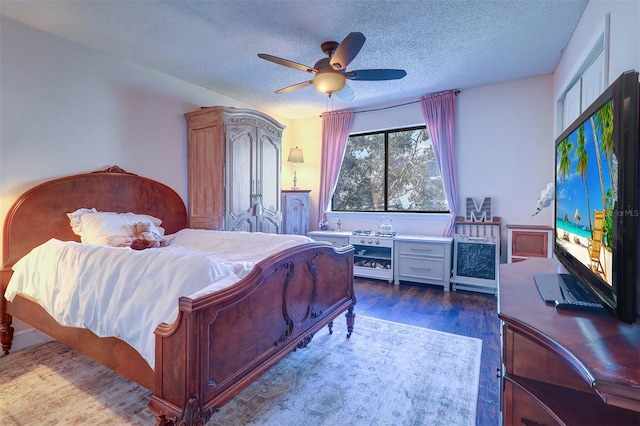 bedroom with ceiling fan, wood-type flooring, and a textured ceiling