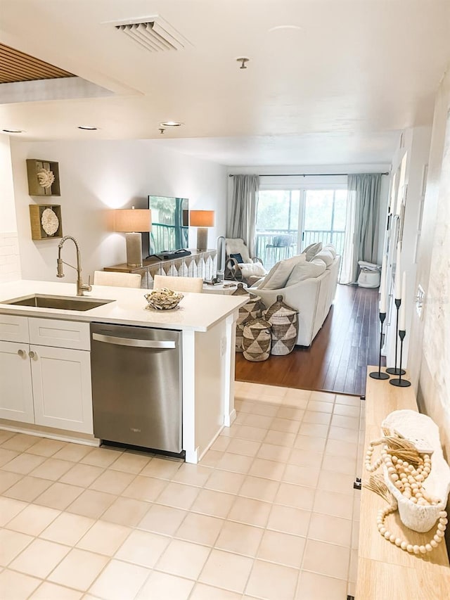 kitchen featuring dishwasher, light wood-type flooring, white cabinetry, and sink