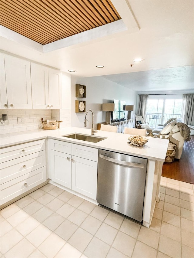 kitchen with dishwasher, white cabinets, kitchen peninsula, and sink