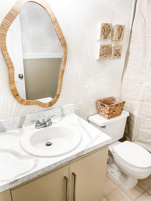 bathroom with tile patterned flooring, vanity, and toilet