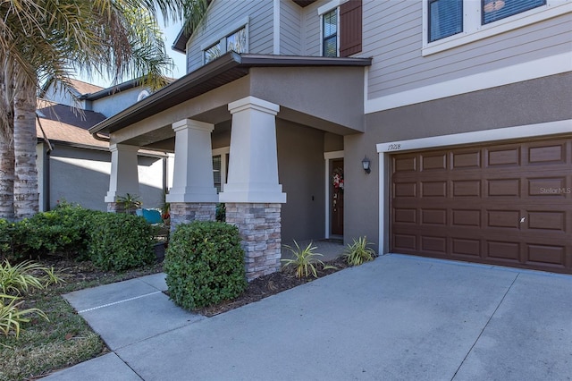 property entrance with a garage, stone siding, and stucco siding