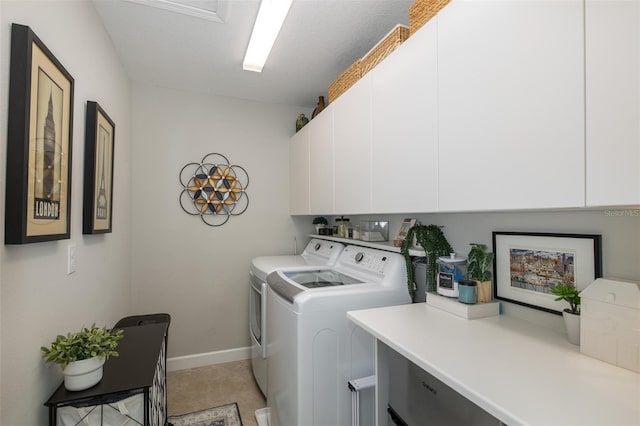 clothes washing area with cabinets and washing machine and dryer