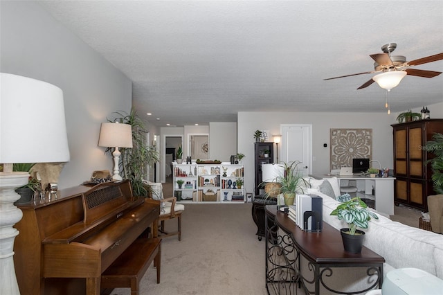 living room featuring ceiling fan, a textured ceiling, and light colored carpet