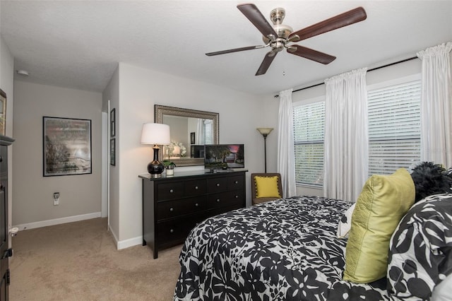 carpeted bedroom featuring a textured ceiling, ceiling fan, and baseboards