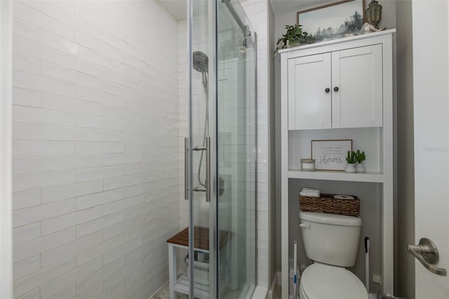 bathroom with toilet and a shower with door