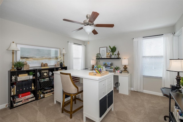 office featuring light carpet, ceiling fan, a wealth of natural light, and baseboards