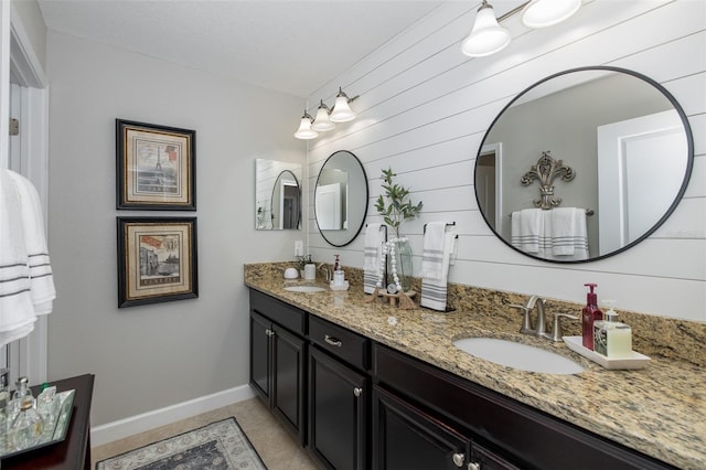 bathroom with tile patterned floors, vanity, and wood walls