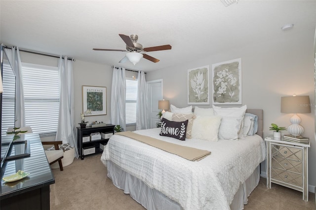 carpeted bedroom featuring a textured ceiling and ceiling fan