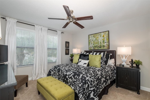 bedroom with light carpet, ceiling fan, and baseboards