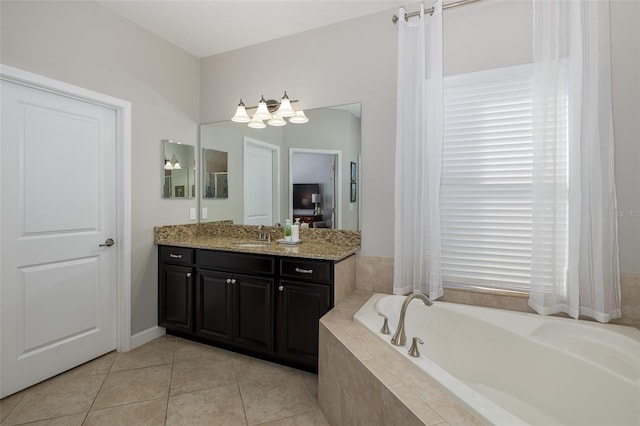 full bath featuring a garden tub, vanity, and tile patterned floors