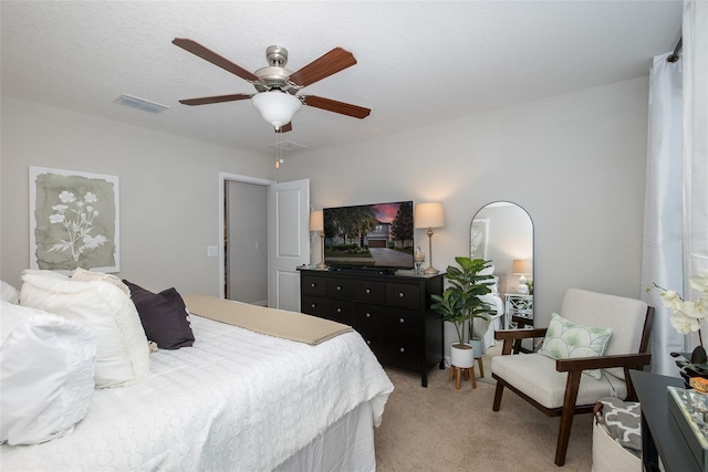 bedroom featuring ceiling fan, visible vents, and light colored carpet