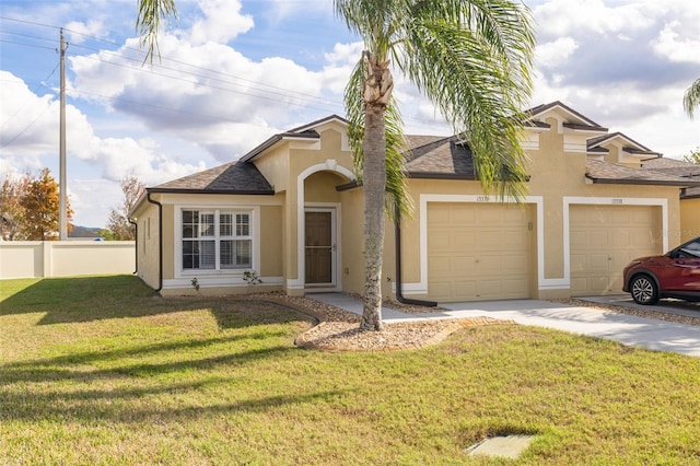 view of front facade with a garage, a shingled roof, stucco siding, fence, and a front yard