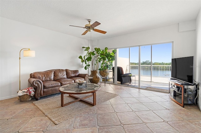 living room with ceiling fan and a textured ceiling