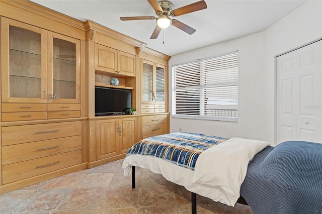 bedroom with ceiling fan, a closet, and a textured ceiling