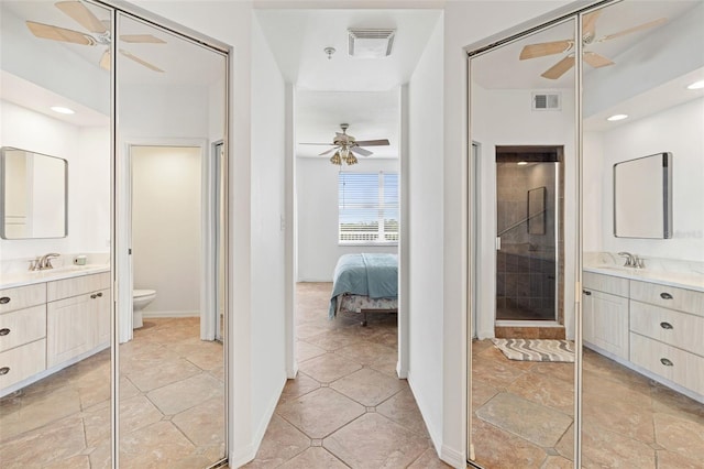 bathroom with an enclosed shower, vanity, and toilet